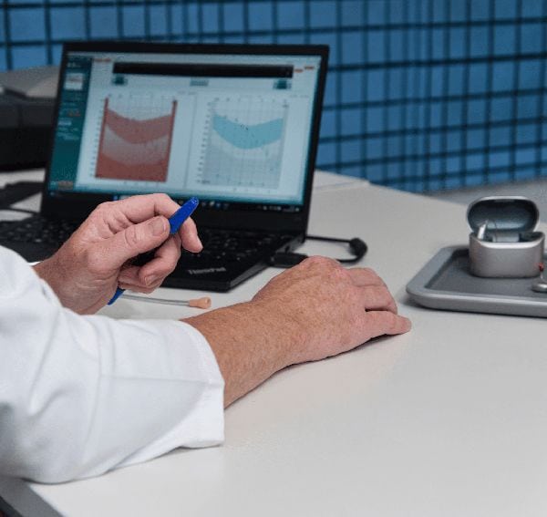 Audicien bekijkt de uitslag van een audiometrie in de meetkamer